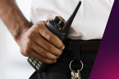 A picture of a presumed security guard holding a walkie-talkie 