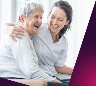 A picture of an older women with a carer in a care home